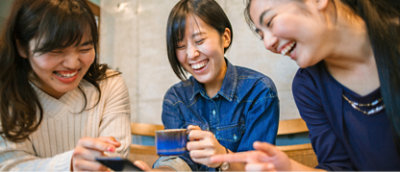 A group of women laughing and holding a cup