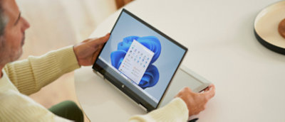 Un homme assis à une table à l’aide d’un ordinateur portable