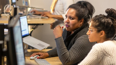 A person sitting on the chair and working with computers