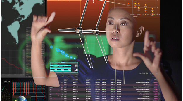 A person pointing at a large screen with graphs