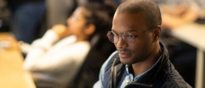 A person wearing glasses and looking away