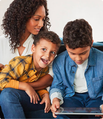 A mother and two children sitting and playing on a couch.