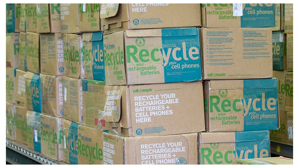 Cardboard boxes labeled ‘Recycle’ for cell phones and batteries.