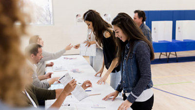 Women stand in row while signing up to vote