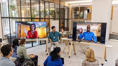 Business people having video call with team in office