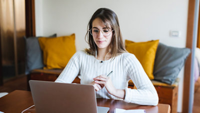 Student woman during E-Learning on laptop at home