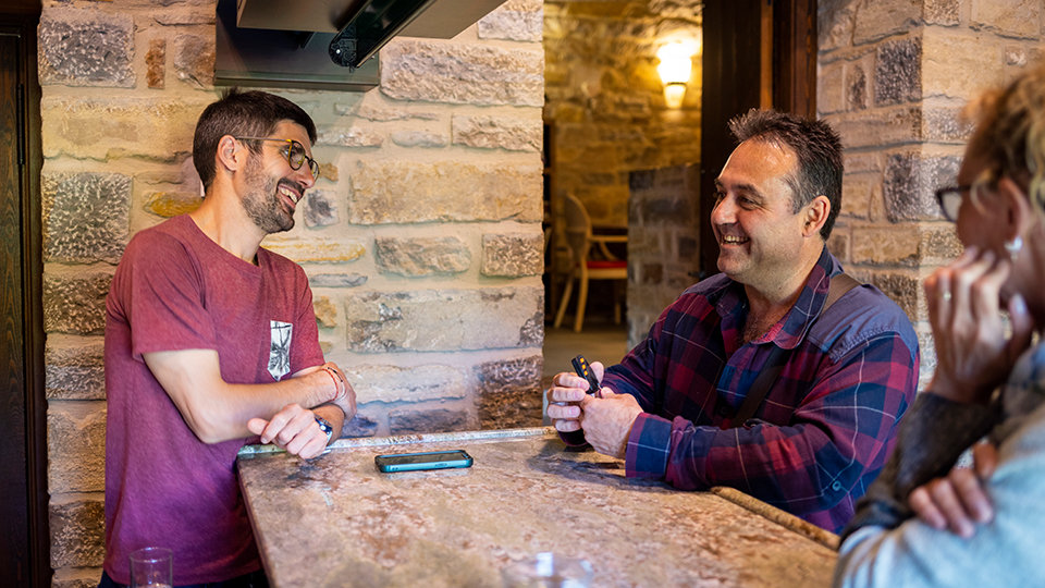 Three people happily talking at a rustic place.