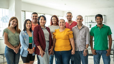 A group of nine people posing together indoors.