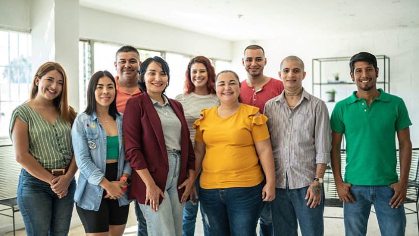 A group of nine people posing together indoors.