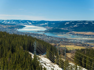 A bird's eye view of a large river flowing through mountains and towns