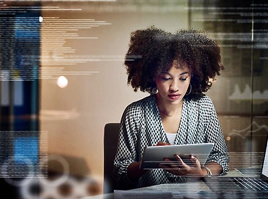 A woman reviewing data on a tablet.