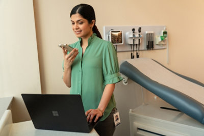 Eine Frau spricht mit einer Patientin, die an einem Tisch sitzt.