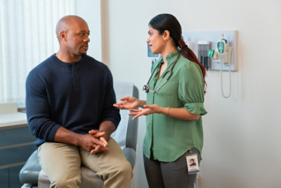 Eine Frau in einem weißen Laborkittel schaut auf einen Computerbildschirm.
