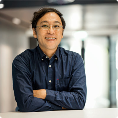 A person with folded hands wearing spects