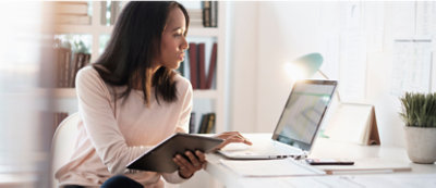 A woman sitting at a desk with a laptop.