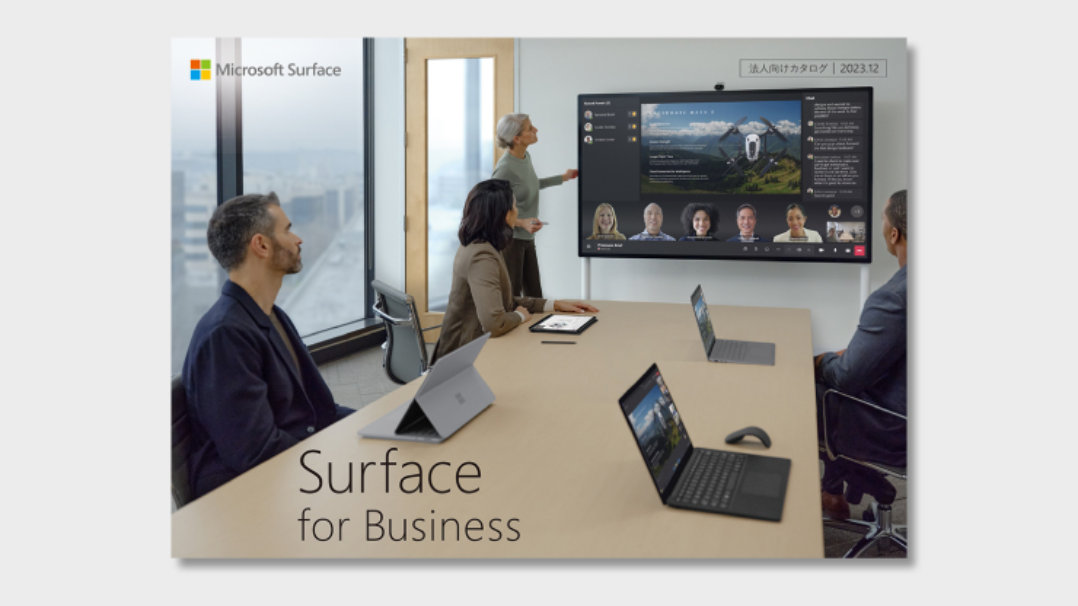 Surface Hub 3でTeamsに参加している座っている3名と立って話している女性
