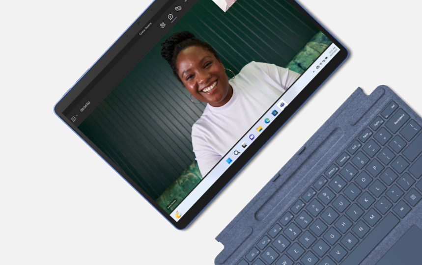 Bild ovanifrån på en Surface Pro 9 med en leende kvinna i ett Teams-samtal på skärmen. 
