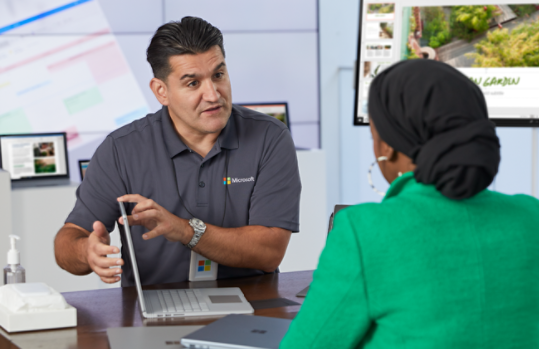 A Microsoft sales associate assists a customer with an in-store consultation.