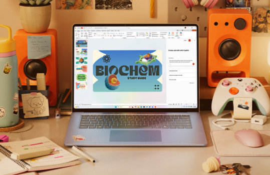A laptop on a colorful desk displays a presentation slide titled Biochem, with study supplies and a game controller nearby.