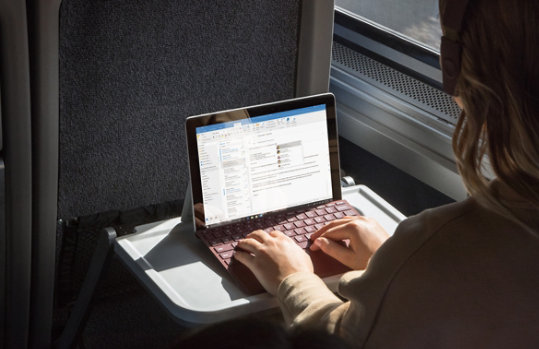 A person uses Surface Go while commuting to work.