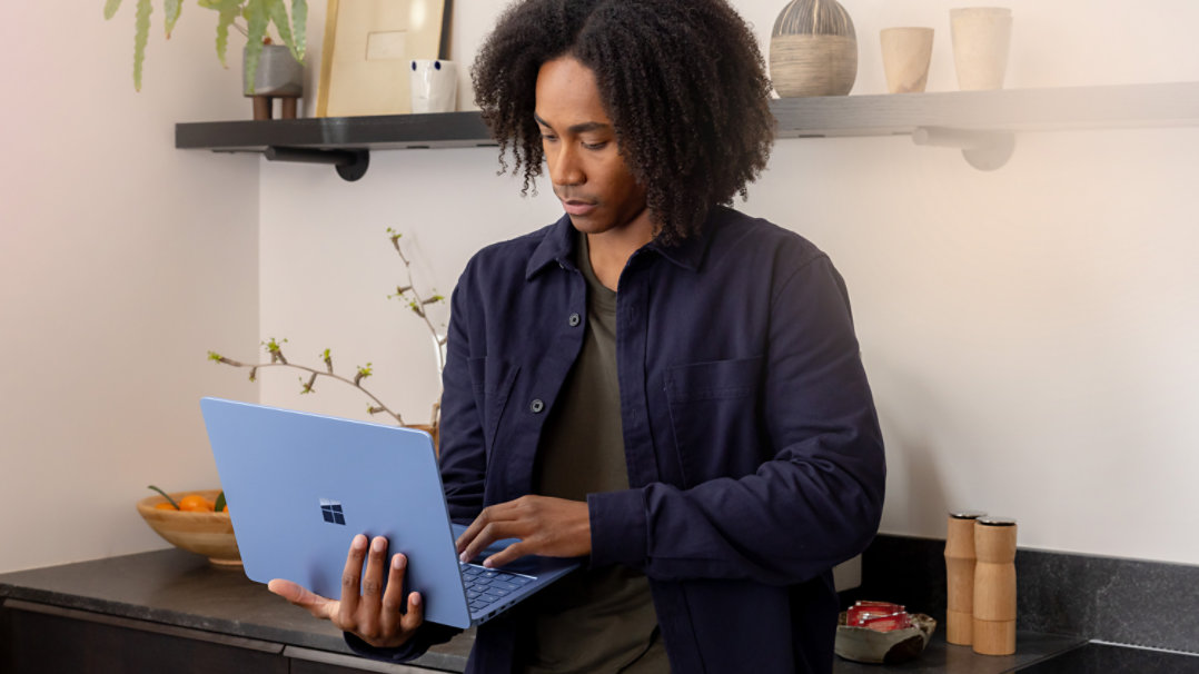 Une personne recherche quelque chose sur son ordinateur portable Surface Saphir. 