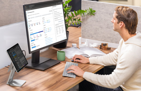 A person at a desktop setup uses a Surface Pro for Business, Copilot+ PC, 12-inch | Snapdragon.