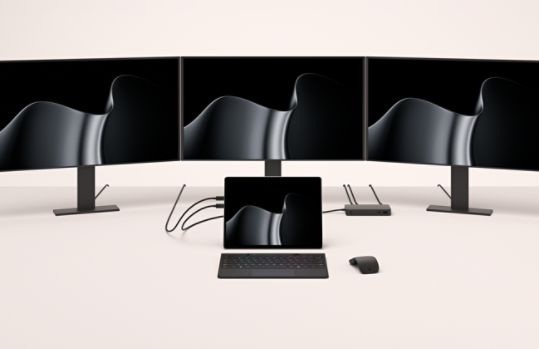A Surface Pro for Business docked to three external monitors.