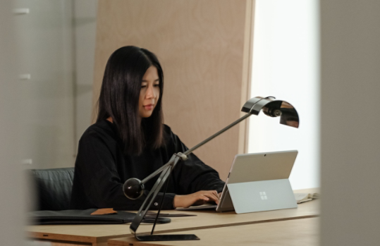 Person verwendet Surface Pro X als Laptop in ihrem Büro.