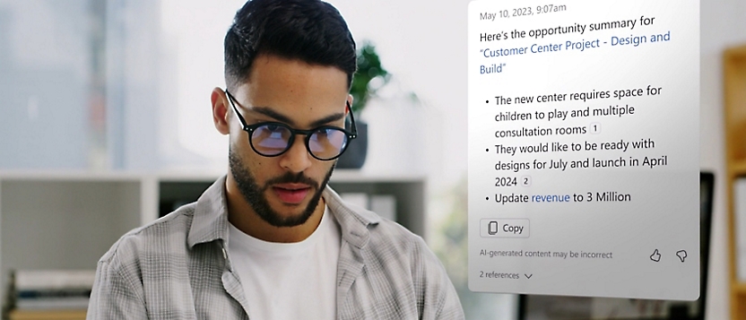 A person wearing spectacles working and to the left a dialog box showing text information