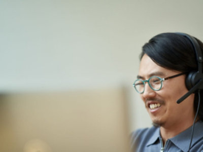 A man wearing a headset while working on a computer.