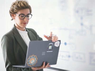 A person in a suit looking at a laptop.
