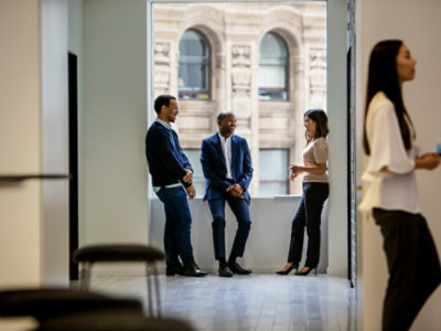A group of people talking in front of a building.