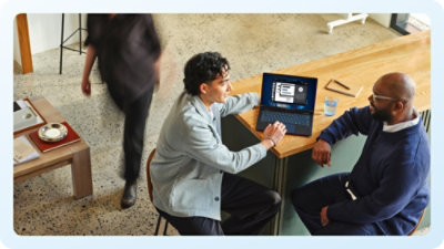 A group of people sitting at a table with a laptop.