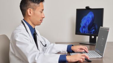 Eine medizinische Fachkraft, die an einem Laptop arbeitet.