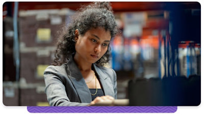 A woman wearing a blazer working at a computer