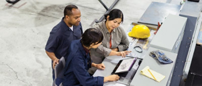 Skupina ljudi gleda v tablični računalnik na mizi.