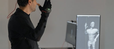 A creative designer working on 3D animation using a mock-up motion capture suit.