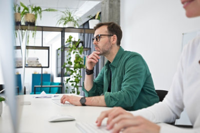 A man and woman looking at a computer screen.