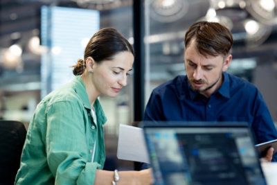 A man and woman looking at a computer screen.
