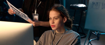 Two colleagues reviewing footage together on a computer while on set.