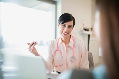 Eine Frau in einem weißen Kittel und mit einem Stethoskop