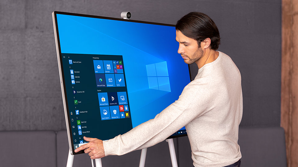 A person uses the touch screen feature on the Surface Hub 2 S.