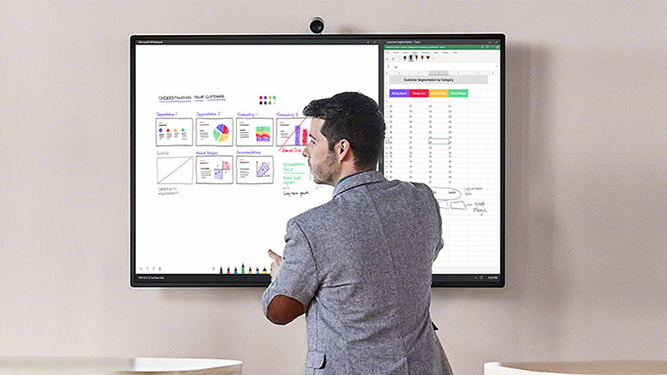 A person uses the Whiteboard feature on a Surface Hub 2 S.