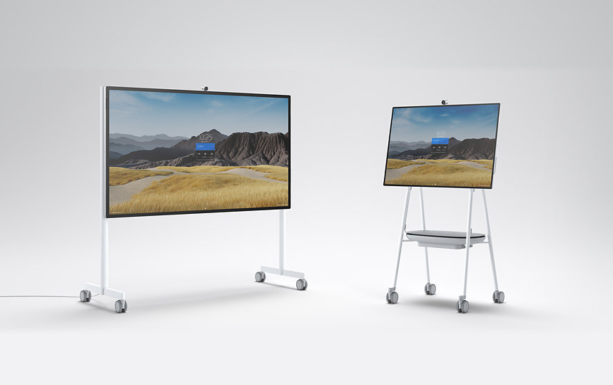 Two Surface Hub 2S devices on mobile stands.