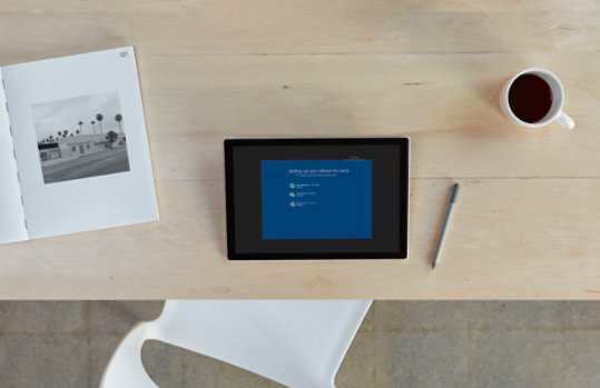 Overhead view of a desktop with a PC, pen, magazine, and coffee cup.