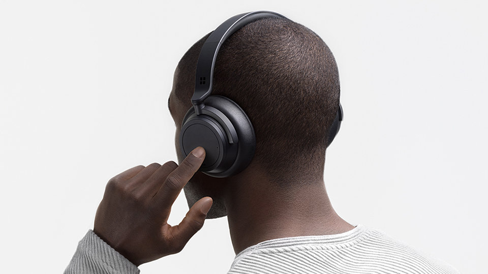 Person listening to the Surface Headphones 2 in Black.
