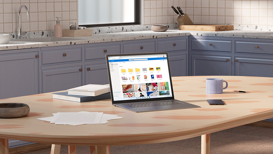 A Microsoft Surface laptop displaying the file explorer at a kitchen table.
