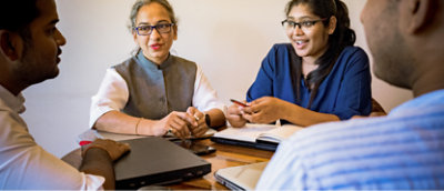 Bir masa etrafında görüşme yapan dört profesyonel.