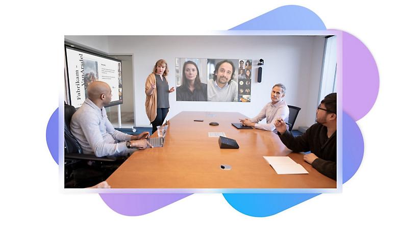 Four people in a meeting room and a Teams video call using intelligent speakers being displayed on the wall behind them.