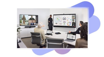 Quatre personnes dans une salle de réunion avec deux grands écrans affichant une présentation et un appel vidéo Teams et des ordinateurs portables et un haut-parleur intelligent Sennheiser TeamConnect sur la table.